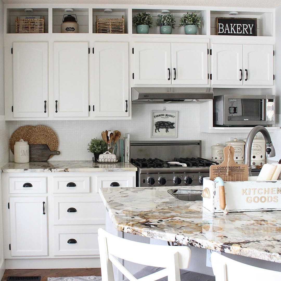 Adding Cabinets to Kitchen: 6 Ways to Gain Storage and Style 3 White kitchen cabinets with marble countertops, a stove, and additional open shelving above the upper cabinets.