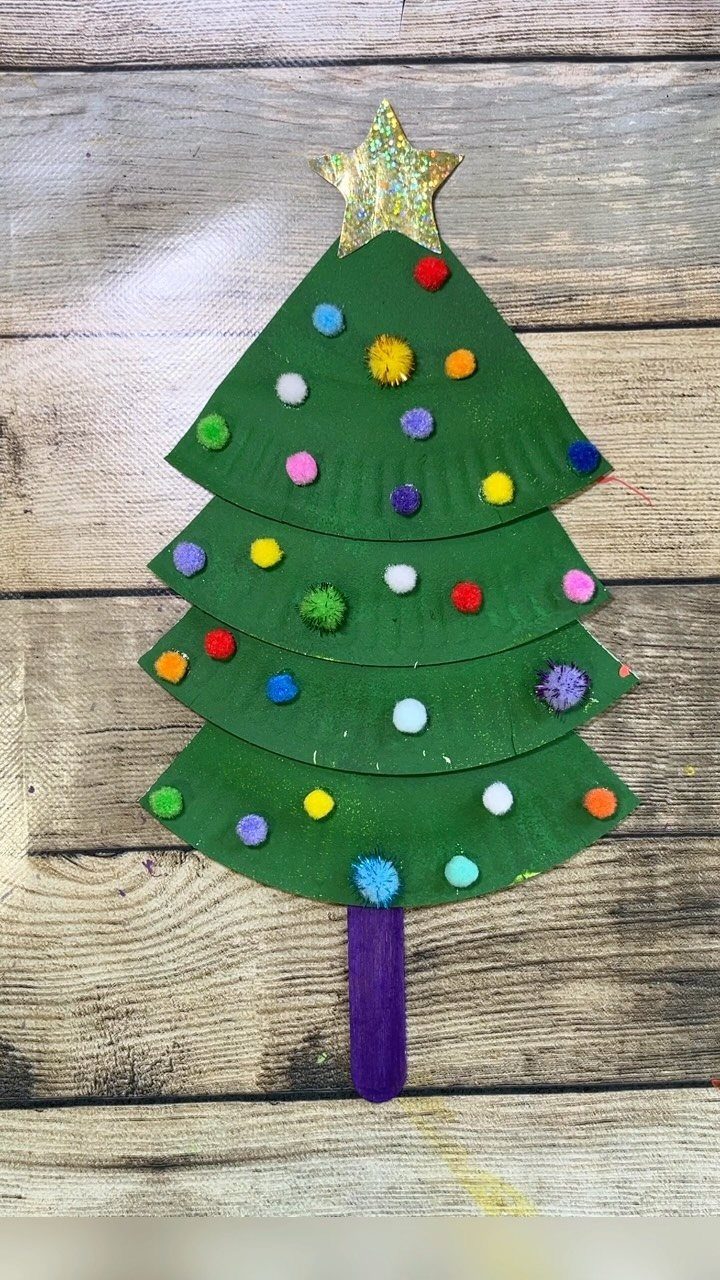 25 Christmas Art and Craft Ideas for Cards, Ornaments, and Decor 6 A green paper plate Christmas tree decorated with colorful pom-poms and a gold star.