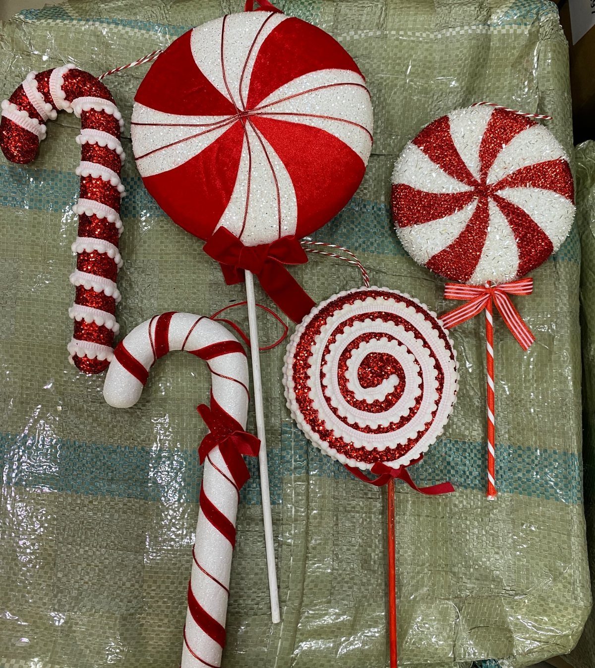 21 DIY Christmas Ornaments for Adults 2 Red and white glittery fabric candy cane and peppermint swirl ornaments with red bows.