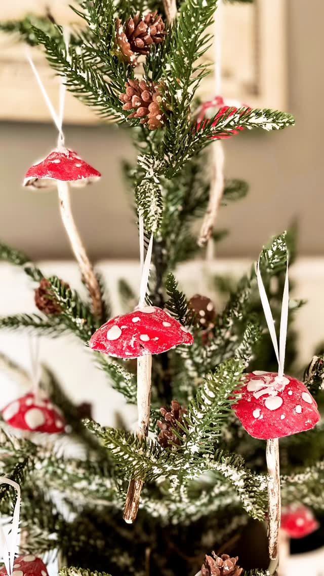 21 DIY Christmas Ornaments for Adults 3 Red and white mushroom ornaments hanging on the branches of a green Christmas tree.