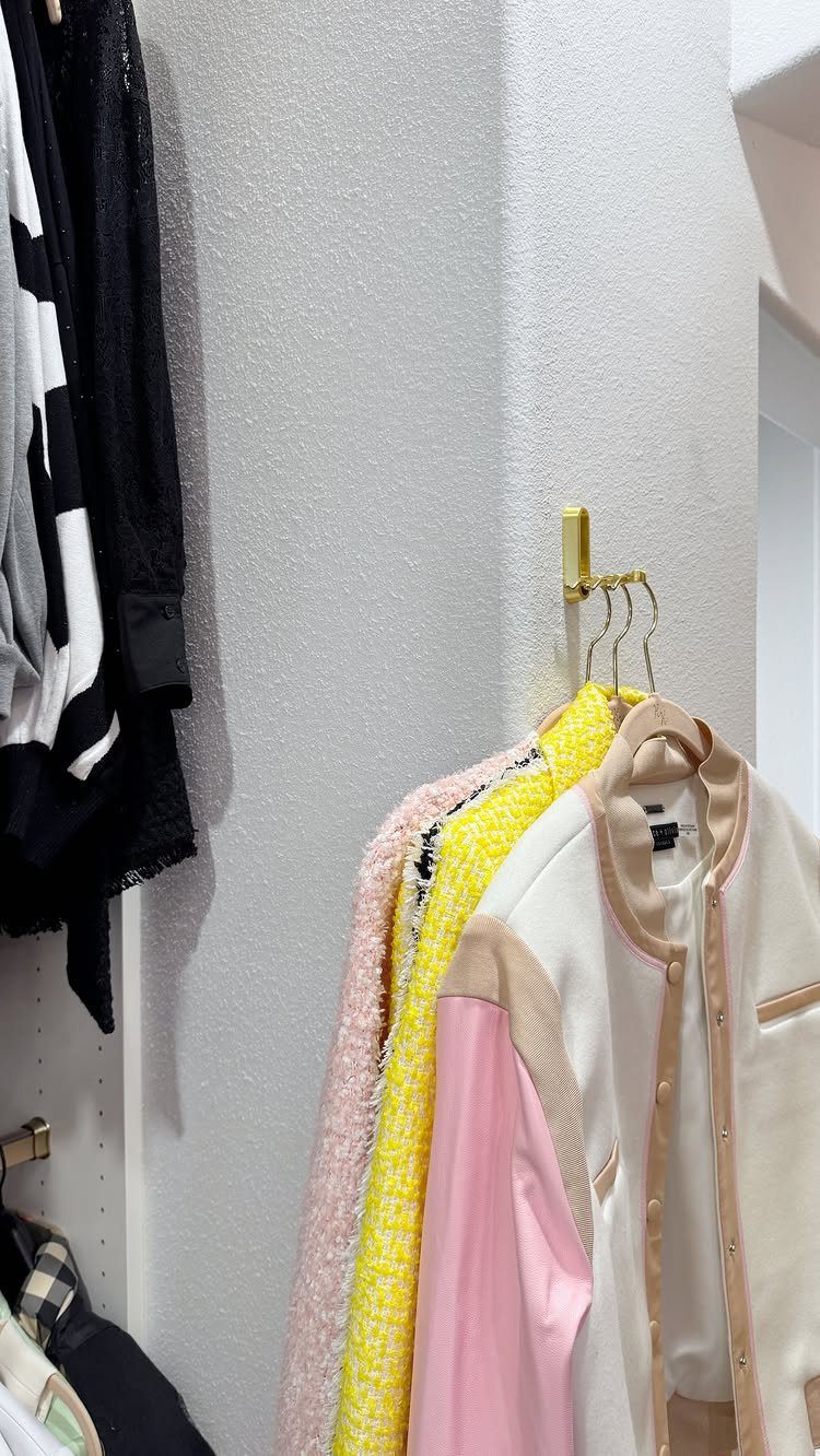 10 DIY Closet Ideas for Room With No Closet 1 Colorful jackets hanging from gold metal hooks mounted on a white wall.