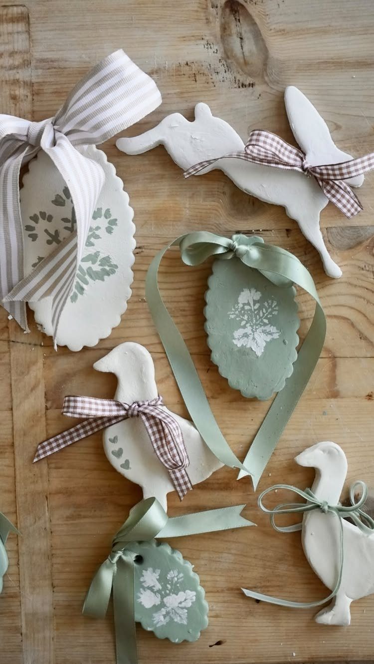 Easy Christmas Clay Ideas: 9 Projects for Handmade Ornaments 1 White clay ornaments shaped like birds and rabbits with ribbons on a wooden table.
