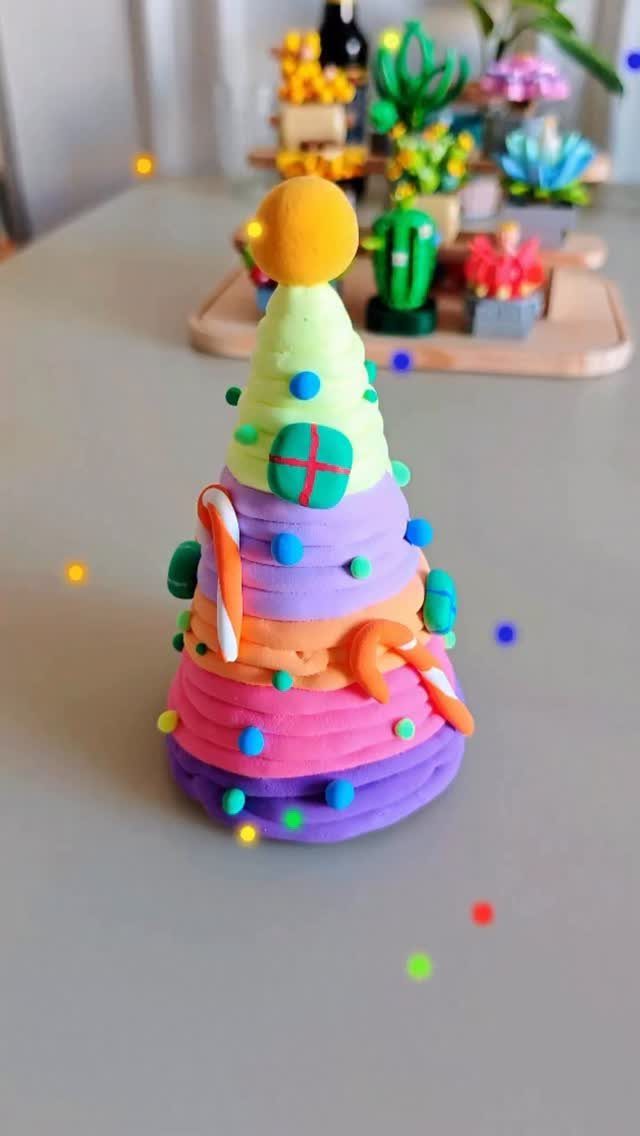 Easy Christmas Clay Ideas: 9 Projects for Handmade Ornaments 2 A colorful conical Christmas tree made from layered rainbow-colored clay with small blue decorations.