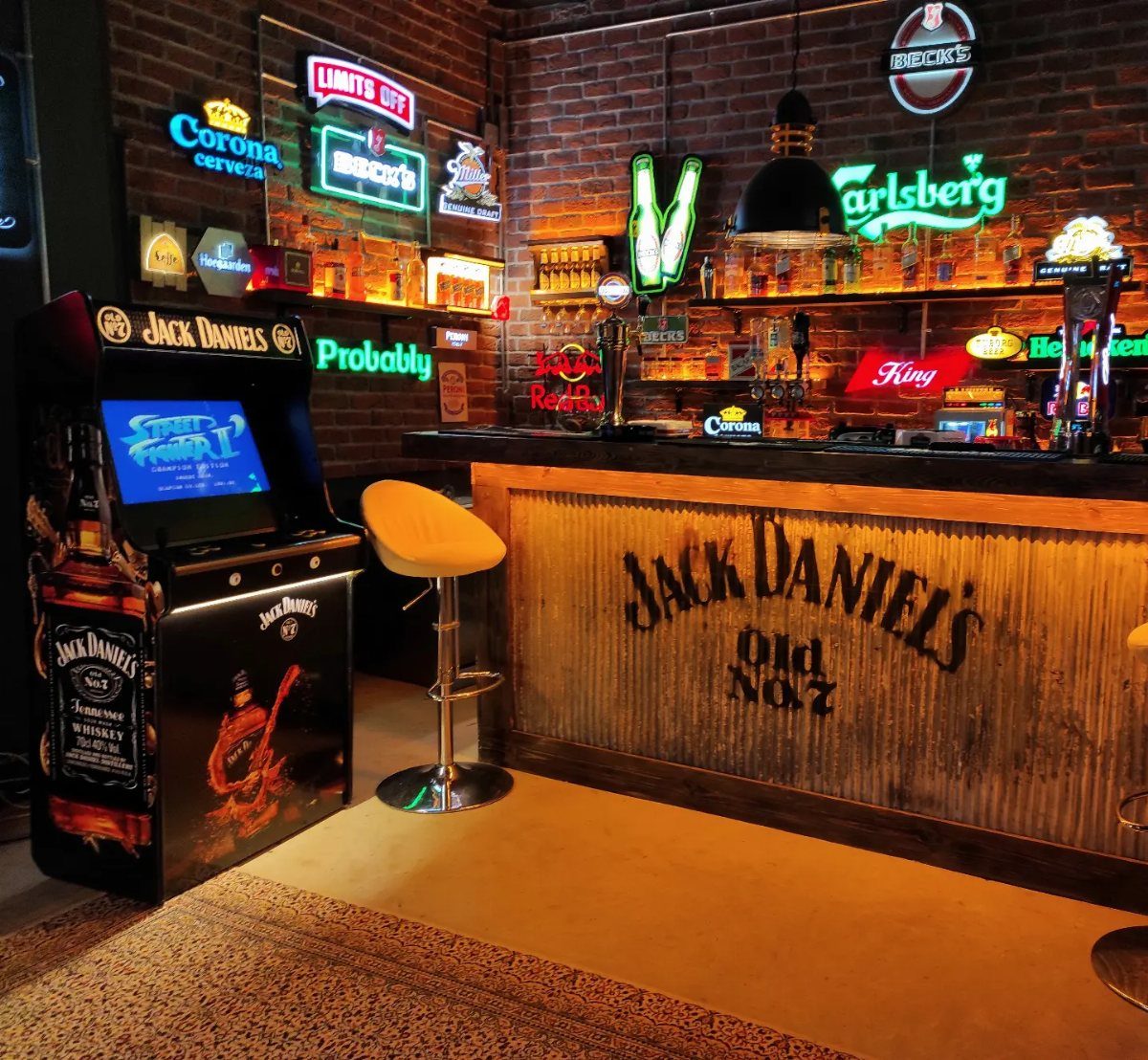 Jack Daniel's themed bar counter and arcade game cabinet in a neon-lit room.