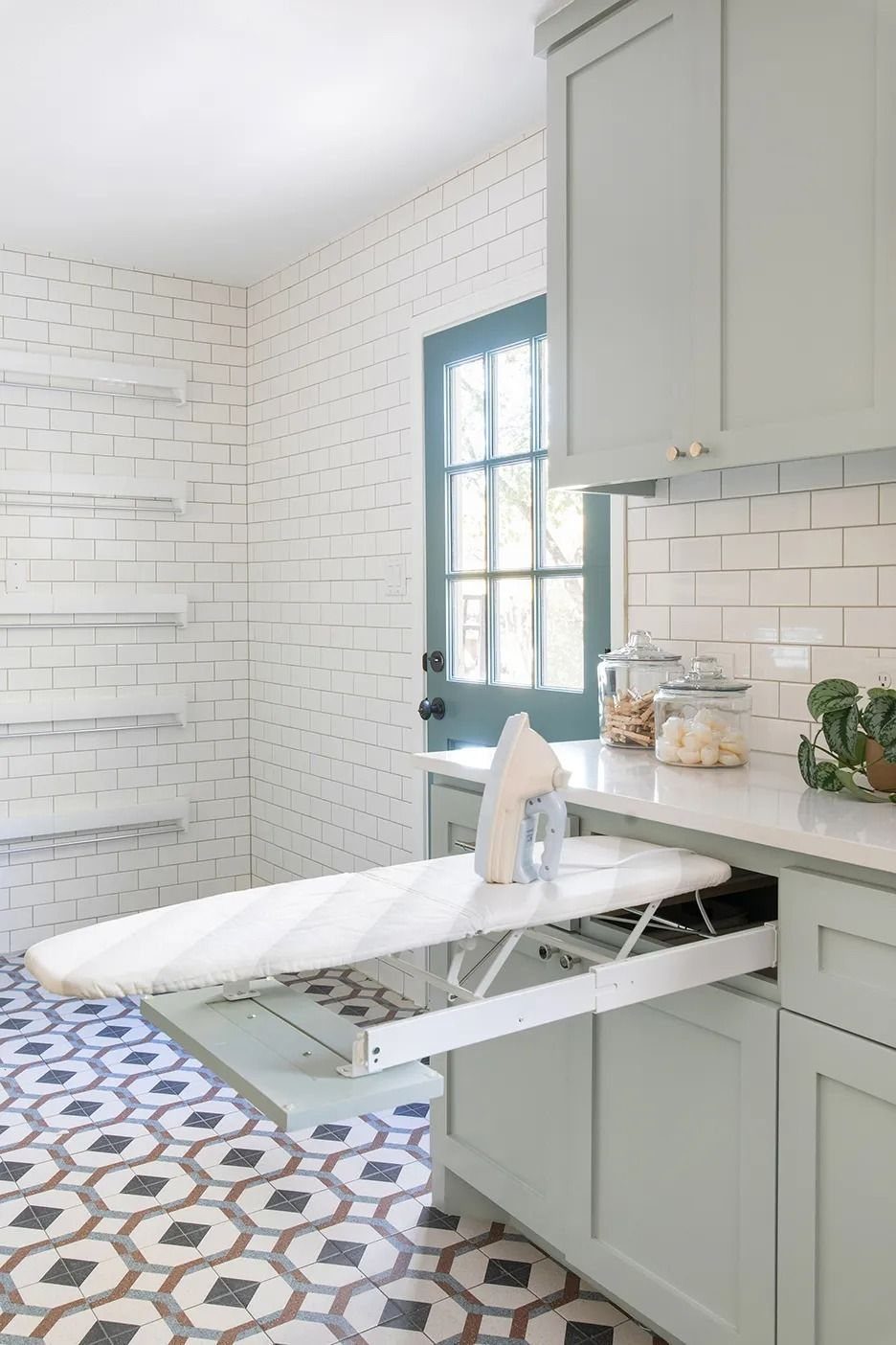 11 Garage Laundry Room Ideas for Storage, Style and Smart Layouts 11 A white padded ironing board extended from a pull-out drawer in grey laundry room cabinets.
