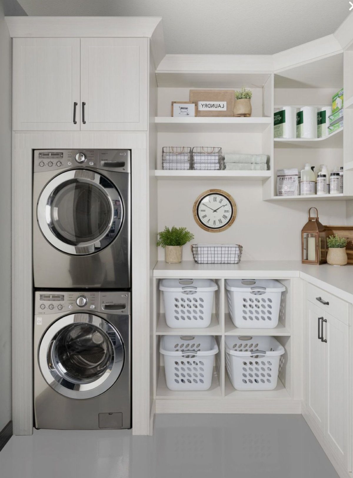 11 Garage Laundry Room Ideas for Storage, Style and Smart Layouts 8 Stacked stainless steel washer and dryer integrated into white laundry room cabinetry with shelving.
