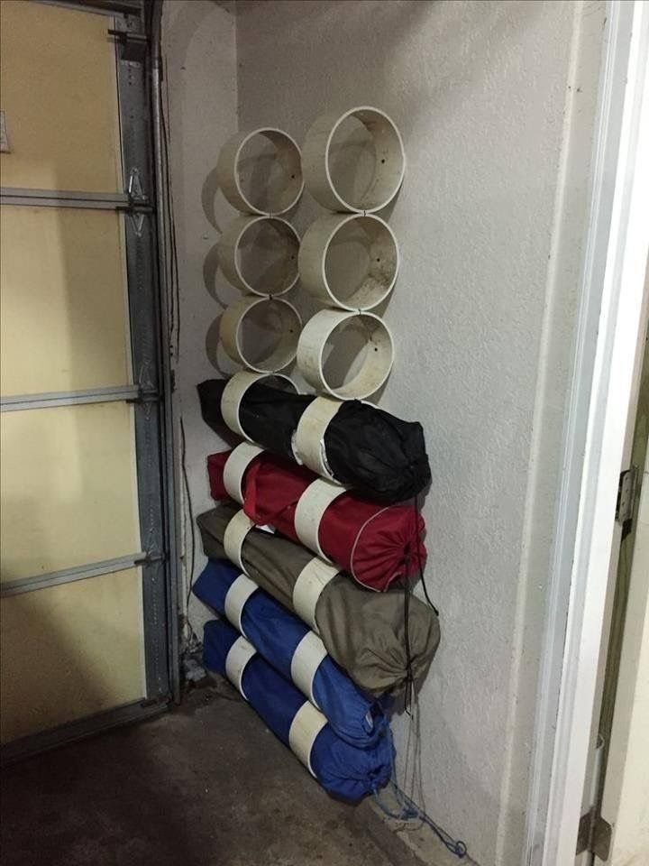 Garage Storage for 4 Camping Chair Ideas That Free the Floor 3 Rolled camping chairs stored in white PVC pipe holders mounted on a garage wall.