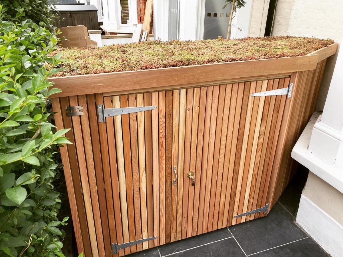 Garden Shed Design: 7 Ways to Use the Space You Have 7 Wooden garden shed with a flat roof covered in green living succulents and moss.