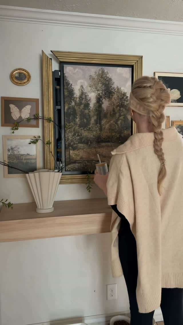 Hidden Storage for Picture Frame: 5 Smart DIY Projects 4 A woman observes a landscape painting that opens like a door to reveal hidden storage space.