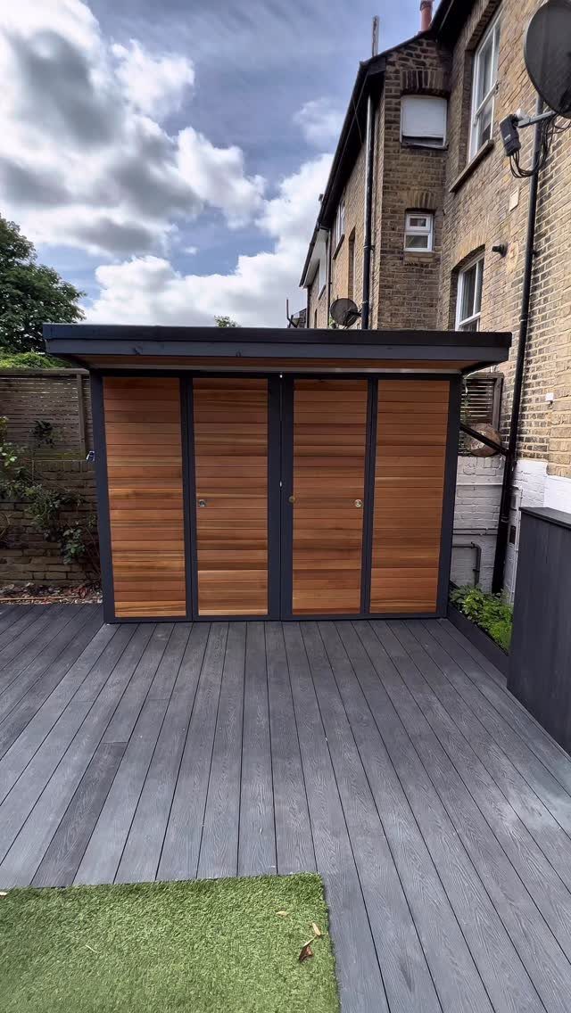 8 Lean-To Shed Ideas for Storage, Parking and Backyard Layouts 3 A modern lean-to shed with wooden slats and dark grey trim on a grey deck.