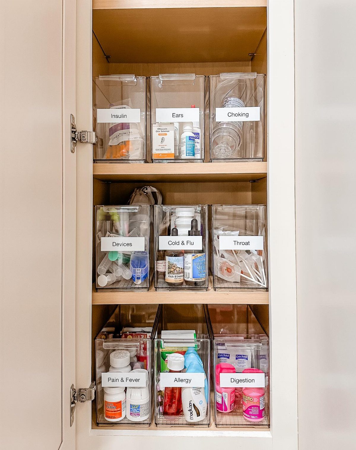 Medicine Cabinet Organization: 5 Fixes to Try in 2026 3 Clear acrylic bins containing labeled medications and medical supplies organized on white cabinet shelves.