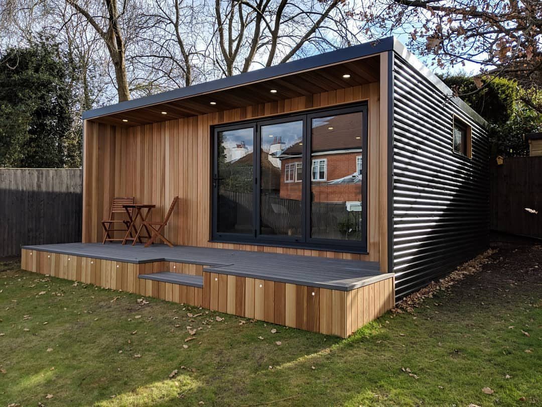 7 Modern Shed Ideas for Compact Yards, Studios & Integrated Outdoor Living 3 Modern garden shed with light wood front, black corrugated sides, and large glass sliding doors.