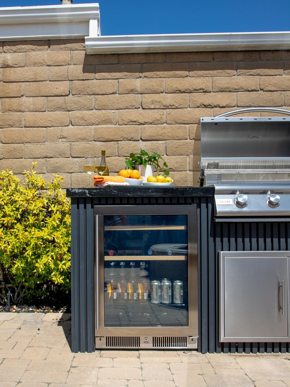 5 Outdoor Kitchen Fridge Ideas for Your Patio Setup 2 A stainless steel beverage cooler with a glass door built into an outdoor kitchen island.