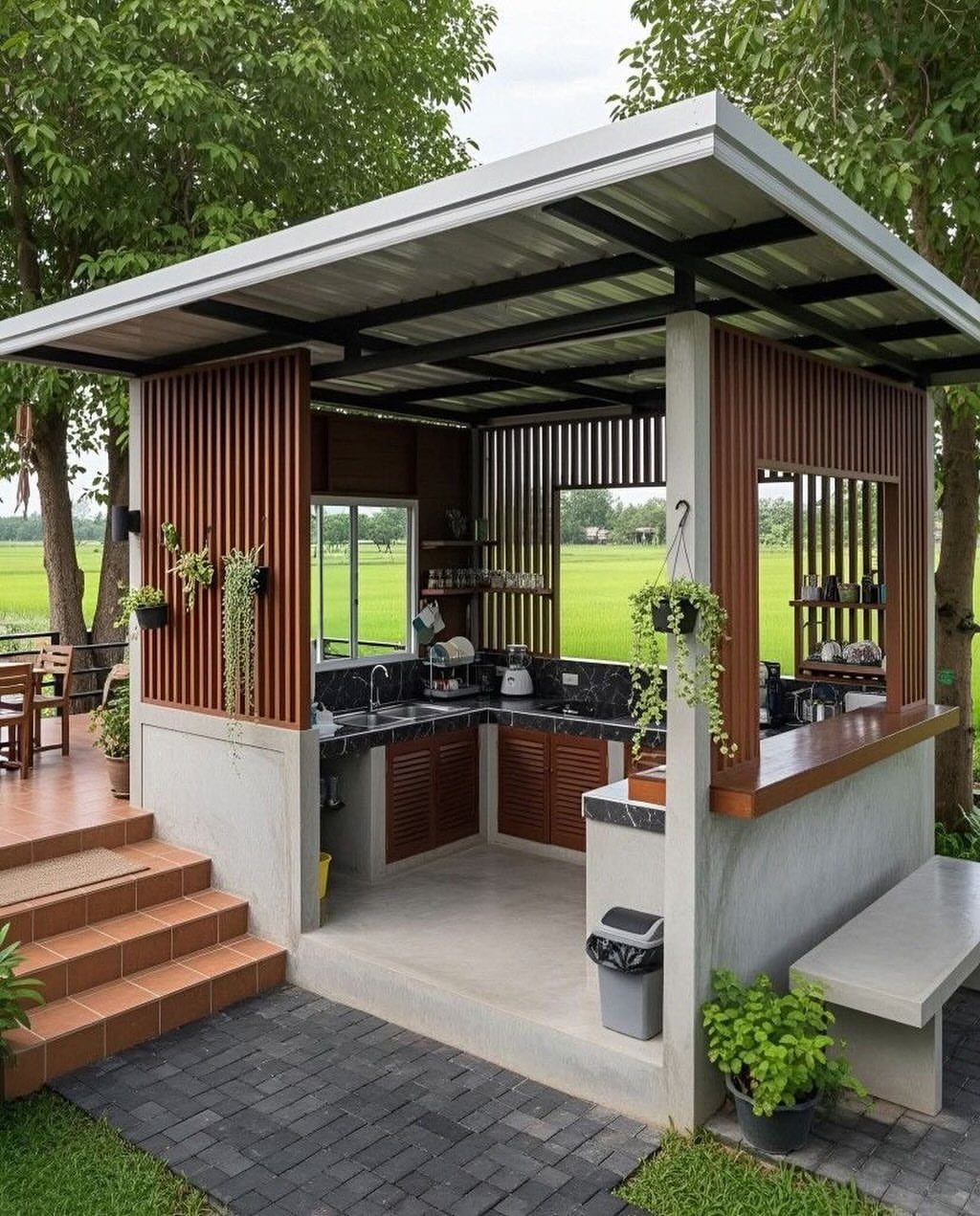 Outdoor Kitchen No Grill: 8 Ideas for Cooking Outside 6 A modern outdoor kitchen structure with wooden cabinets, dark countertops, and hanging plants in a garden setting.