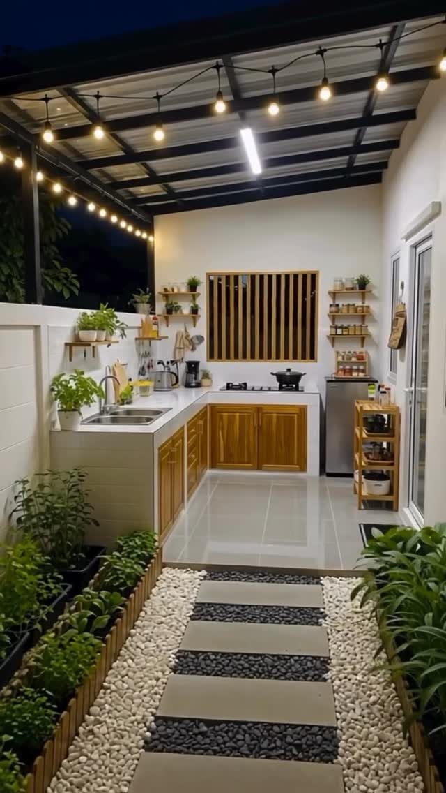 Outdoor Kitchen No Grill: 8 Ideas for Cooking Outside 5 An outdoor kitchen with wooden cabinets, white countertops, a sink, and string lights under a patio cover.