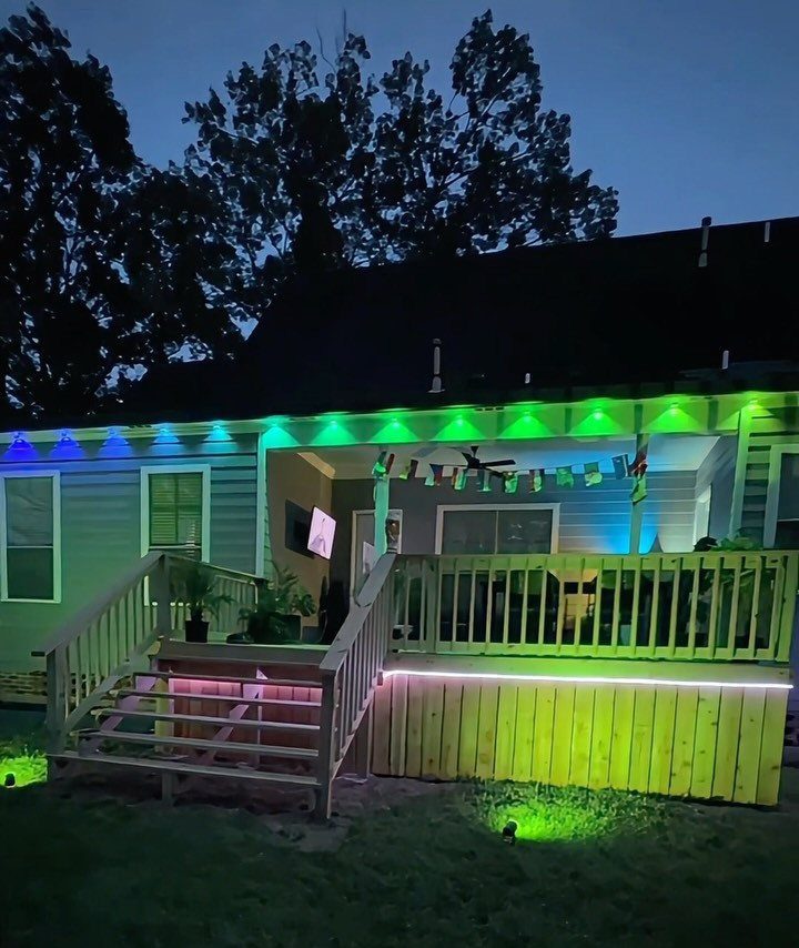 28 Outdoor Wooden Deck Ideas for Any Yard Size 28 Wooden deck illuminated with vibrant green and pink LED strip lighting at dusk.