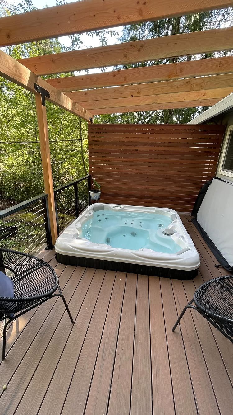 28 Outdoor Wooden Deck Ideas for Any Yard Size 26 A white hot tub sits on a wooden deck under a large wooden pergola structure.
