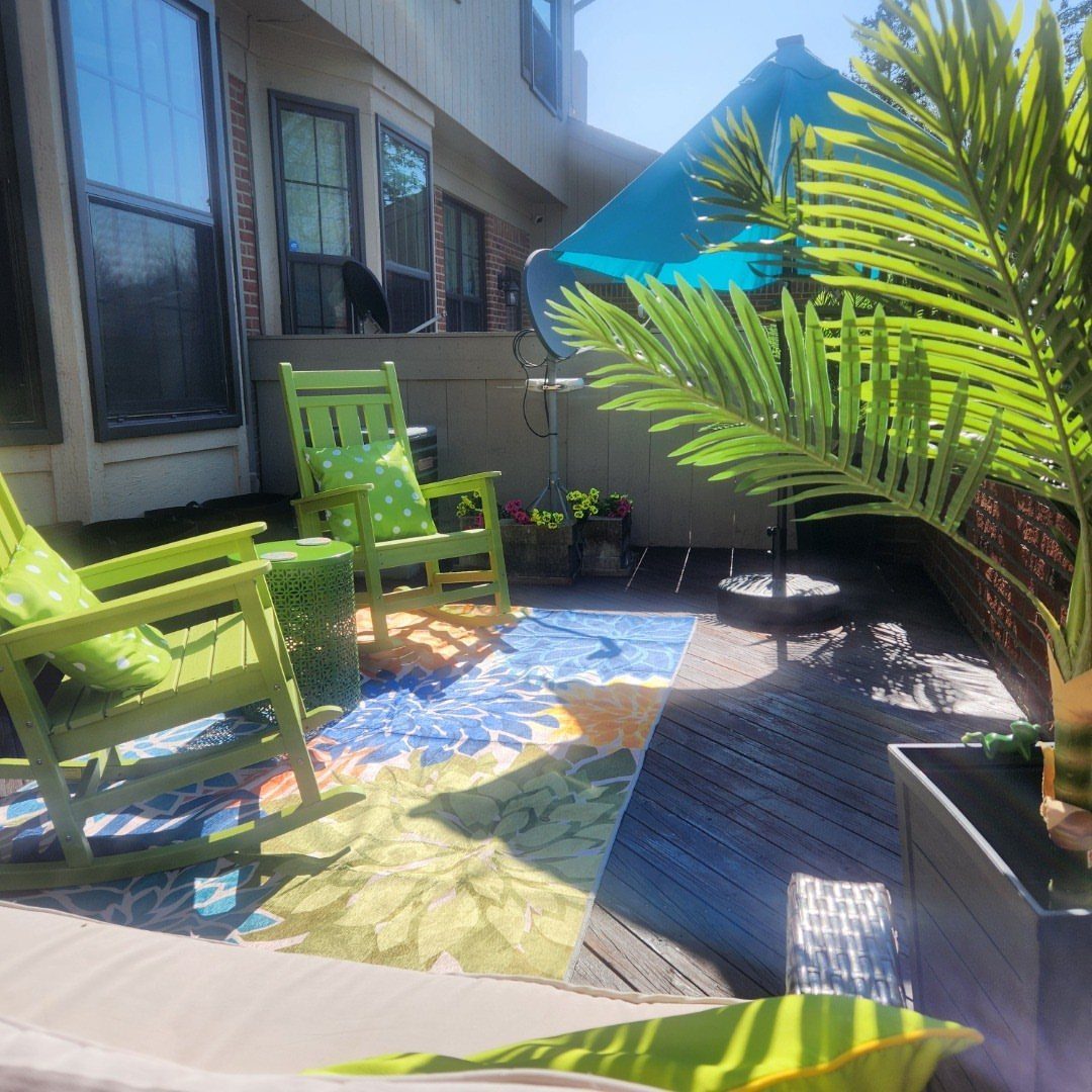 28 Outdoor Wooden Deck Ideas for Any Yard Size 24 Lime green chairs and a colorful patterned rug sit on a wooden outdoor deck.