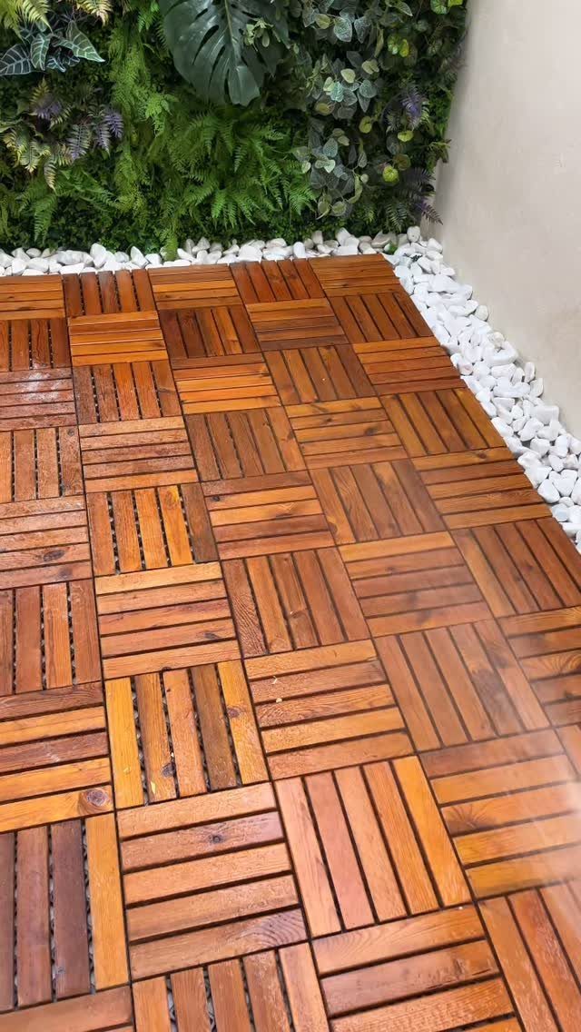 28 Outdoor Wooden Deck Ideas for Any Yard Size 22 Wooden deck tiles in a parquet pattern next to a lush green vertical garden wall.