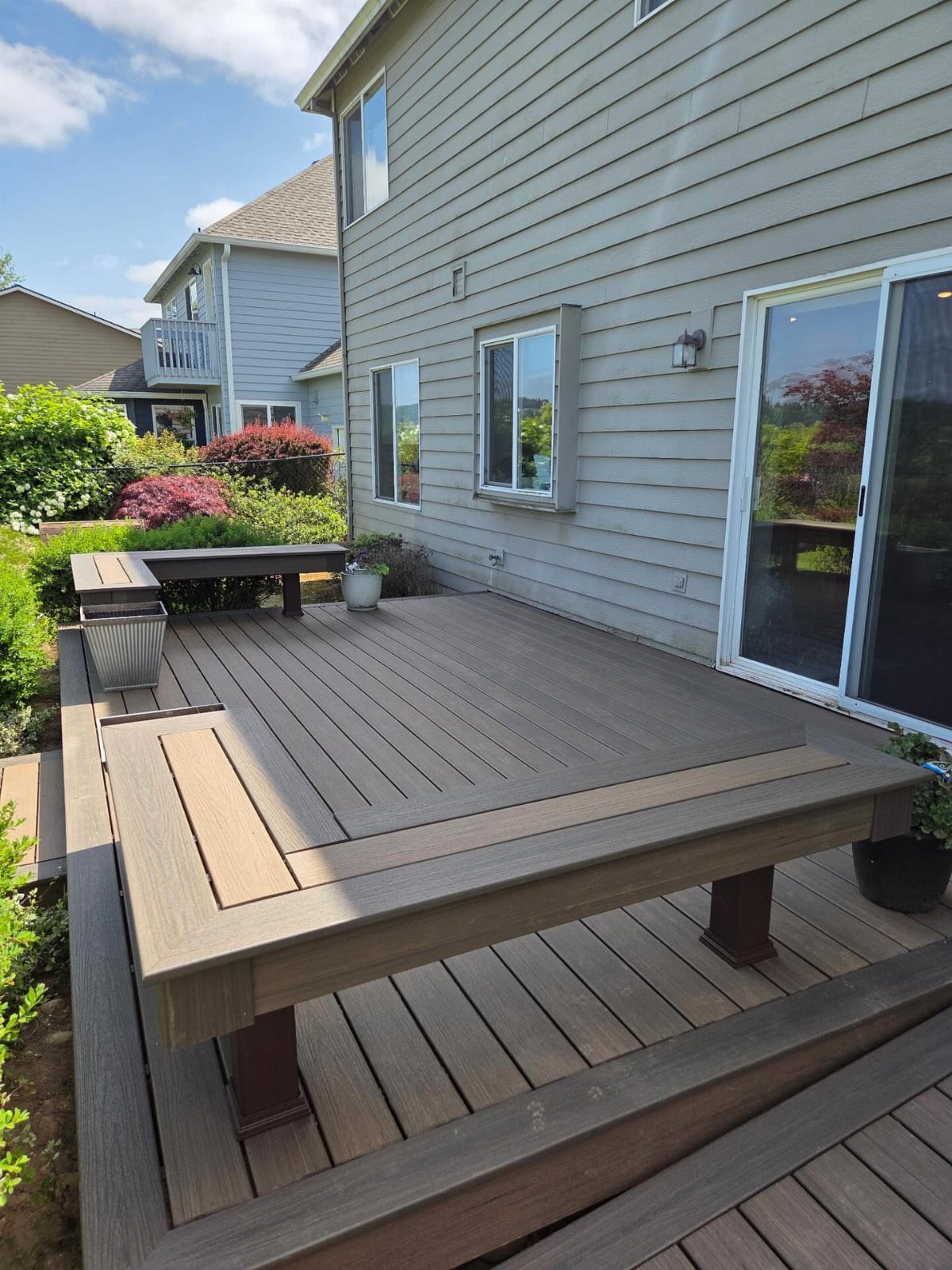 20 Patio and Deck Ideas to Make Your Yard Feel Like a Room 18 A wooden composite deck with a large built-in table surface integrated into the floor.