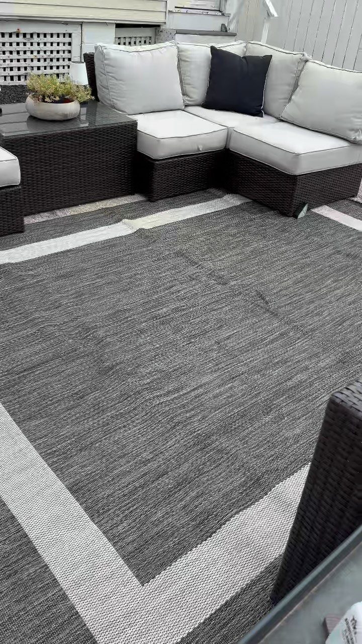 20 Patio and Deck Ideas to Make Your Yard Feel Like a Room 5 A grey textured outdoor rug with a white border pattern on a patio deck.