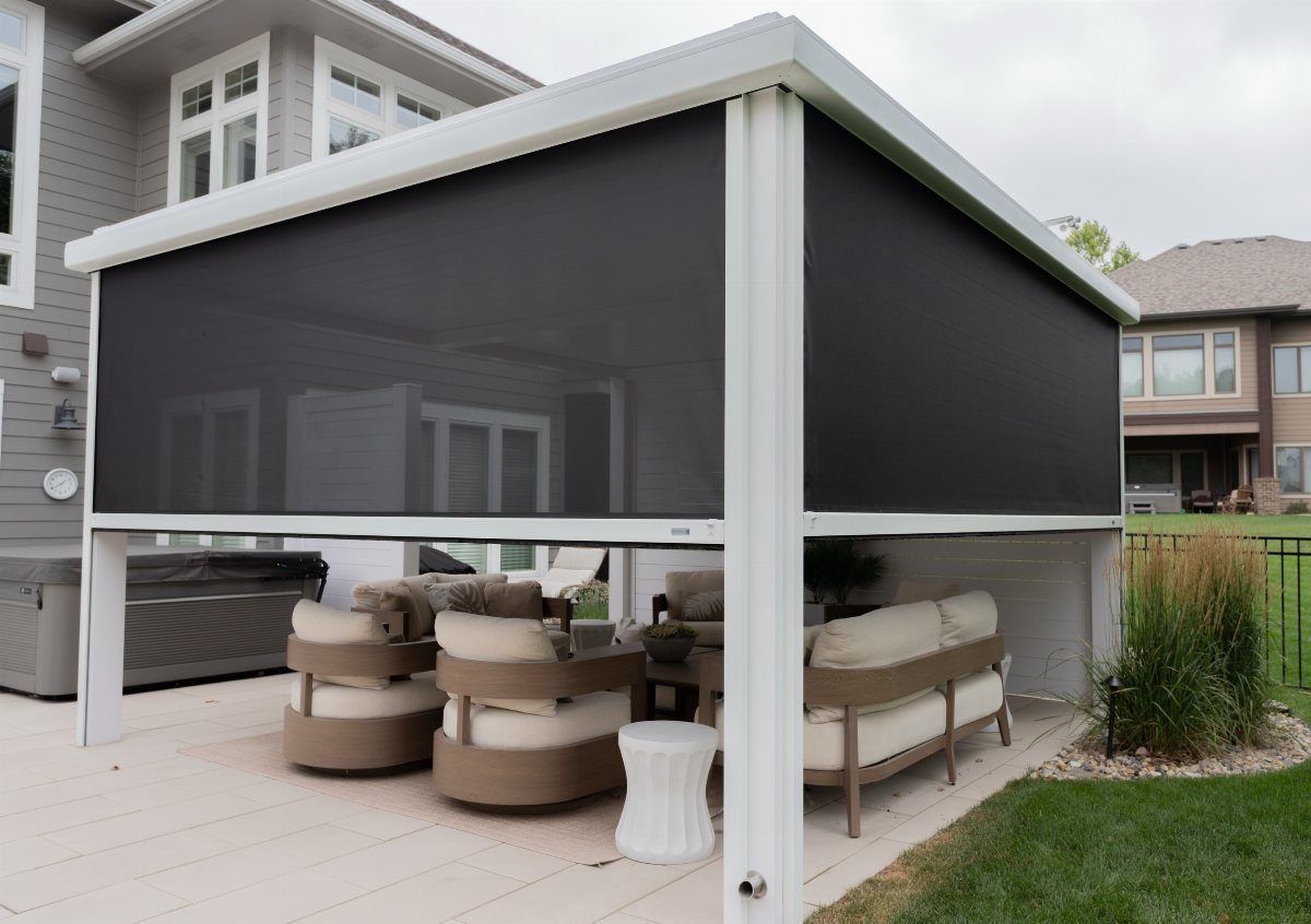 20 Patio and Deck Ideas to Make Your Yard Feel Like a Room 9 Dark mesh retractable privacy screens installed on a white metal patio structure with outdoor furniture.