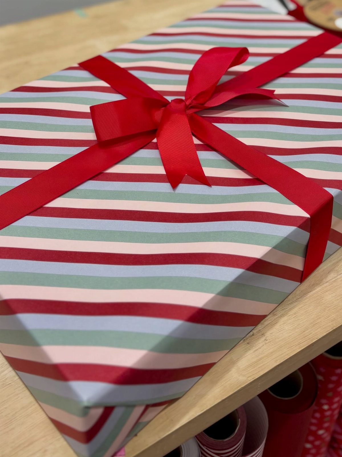 8 Red and Green Christmas Tree Ideas 8 A striped gift box wrapped in red and blue paper with a red satin bow.