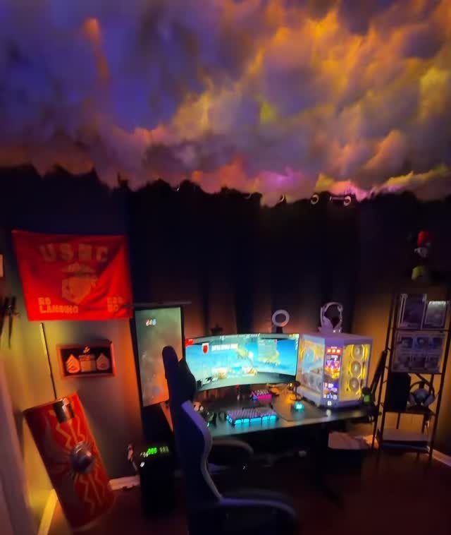 5 Room on Top of Garage Ideas for Extra Living Space 2 Gaming setup with ultrawide monitor, glowing PC, and colorful cloud lighting on the ceiling.