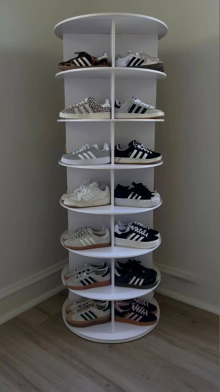 Small Sneaker Collection Closet: 5 Space-Smart Setups 3 A white rotating shoe rack filled with various pairs of sneakers in a room corner.