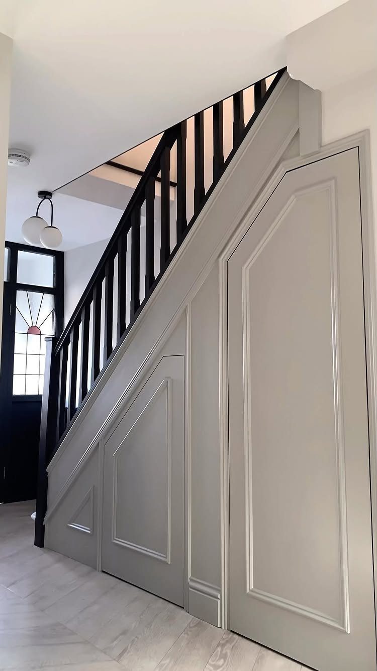 18 Under Stair Storage Design Modern Ideas for Every Home 3 Grey paneled doors integrated into the space underneath a modern staircase.
