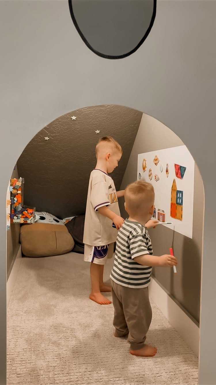 18 Under Stair Storage Design Modern Ideas for Every Home 14 Two young children playing inside a small, arched, built-in secret playroom nook.
