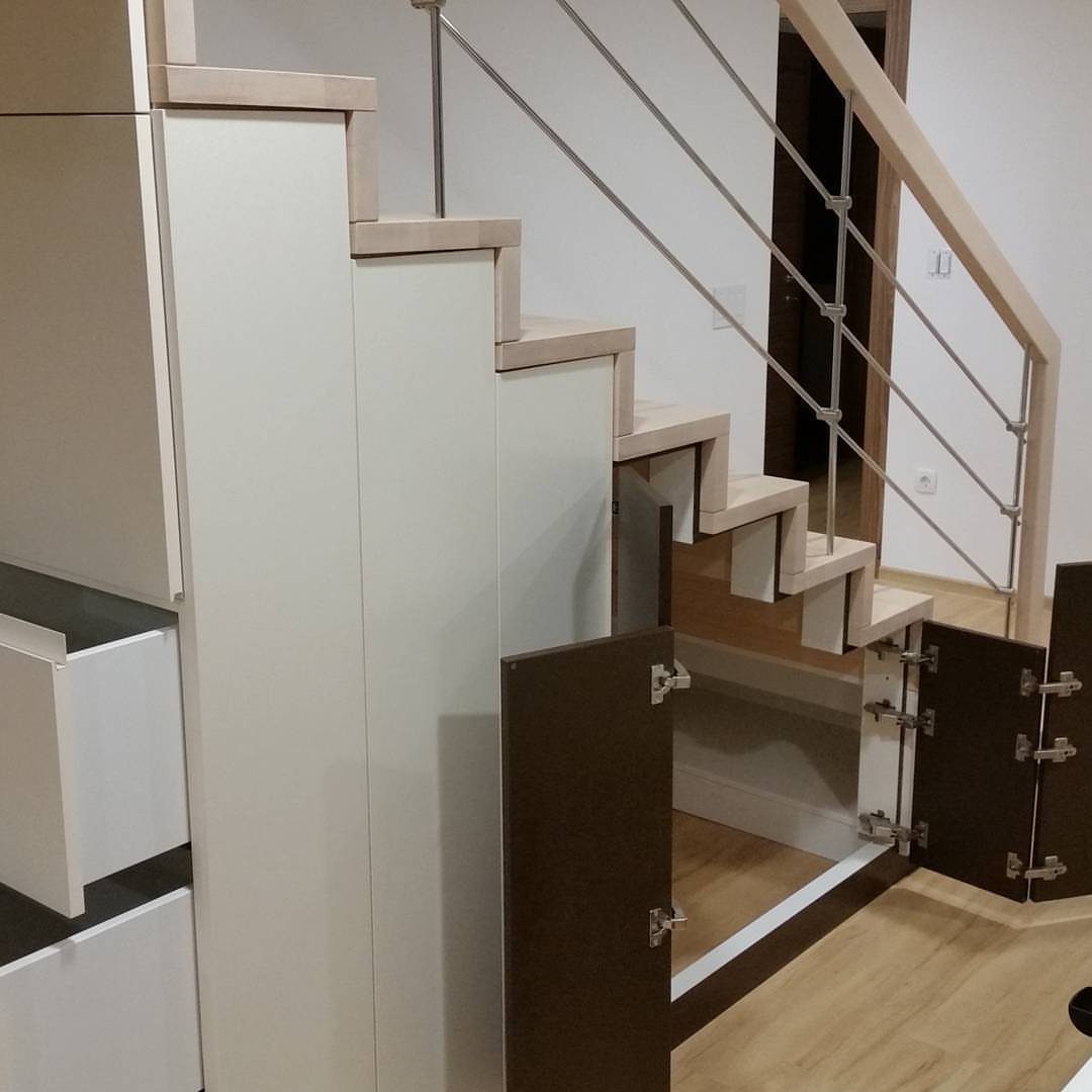 18 Under Stair Storage Design Modern Ideas for Every Home 5 Modern white staircase with open dark brown storage doors underneath the steps.