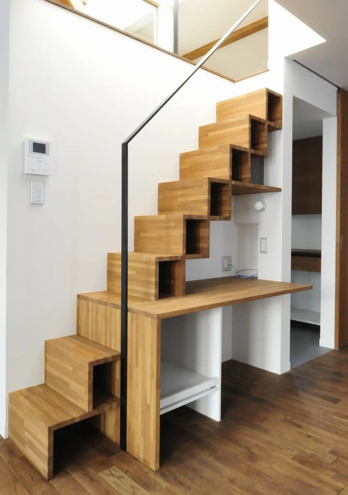 Wooden staircase with integrated cubby storage and a built-in desk underneath the steps.