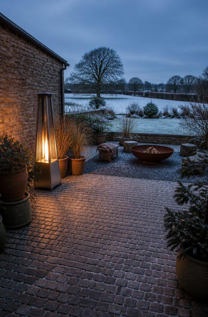 A fire pit set up in a winter garden for warmth.